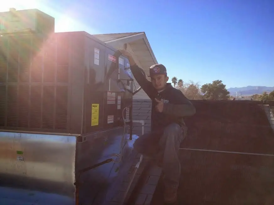 HVAC technician performing AC Tune-Up on a rooftop unit in Findlay
